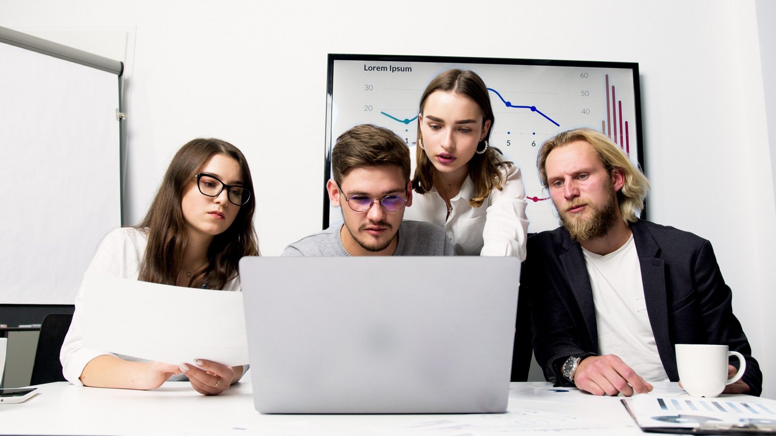 Equipe analisando um projeto de site em um notebook durante uma reunião de orçamento