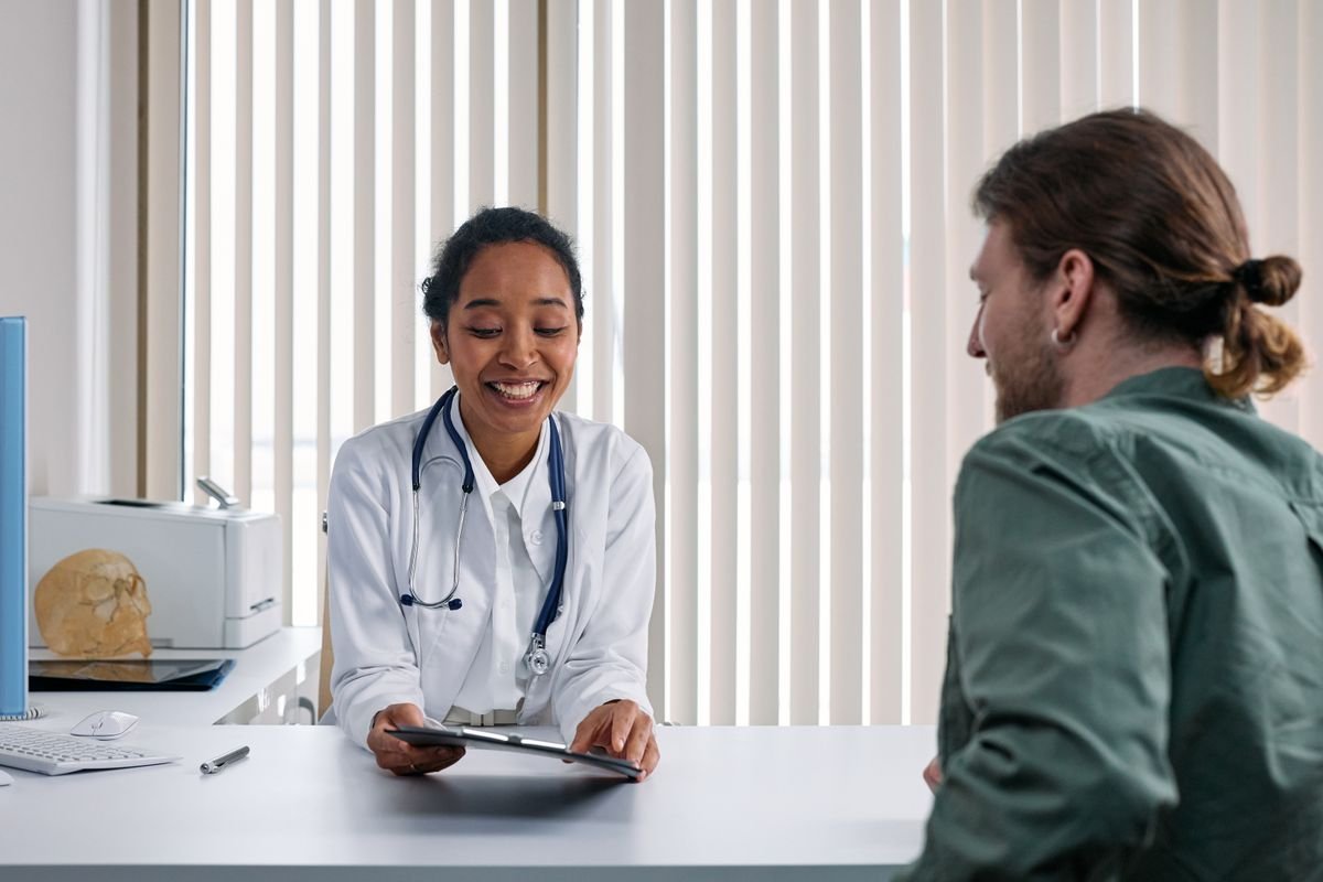 Medico conversando com paciente durante consulta - transcrição médica com IA