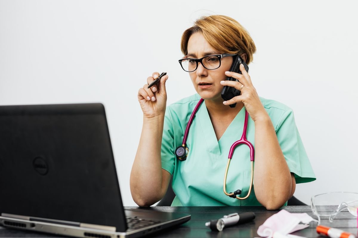 Medico com estetoscopio trabalhando no laptop - IA para medicos